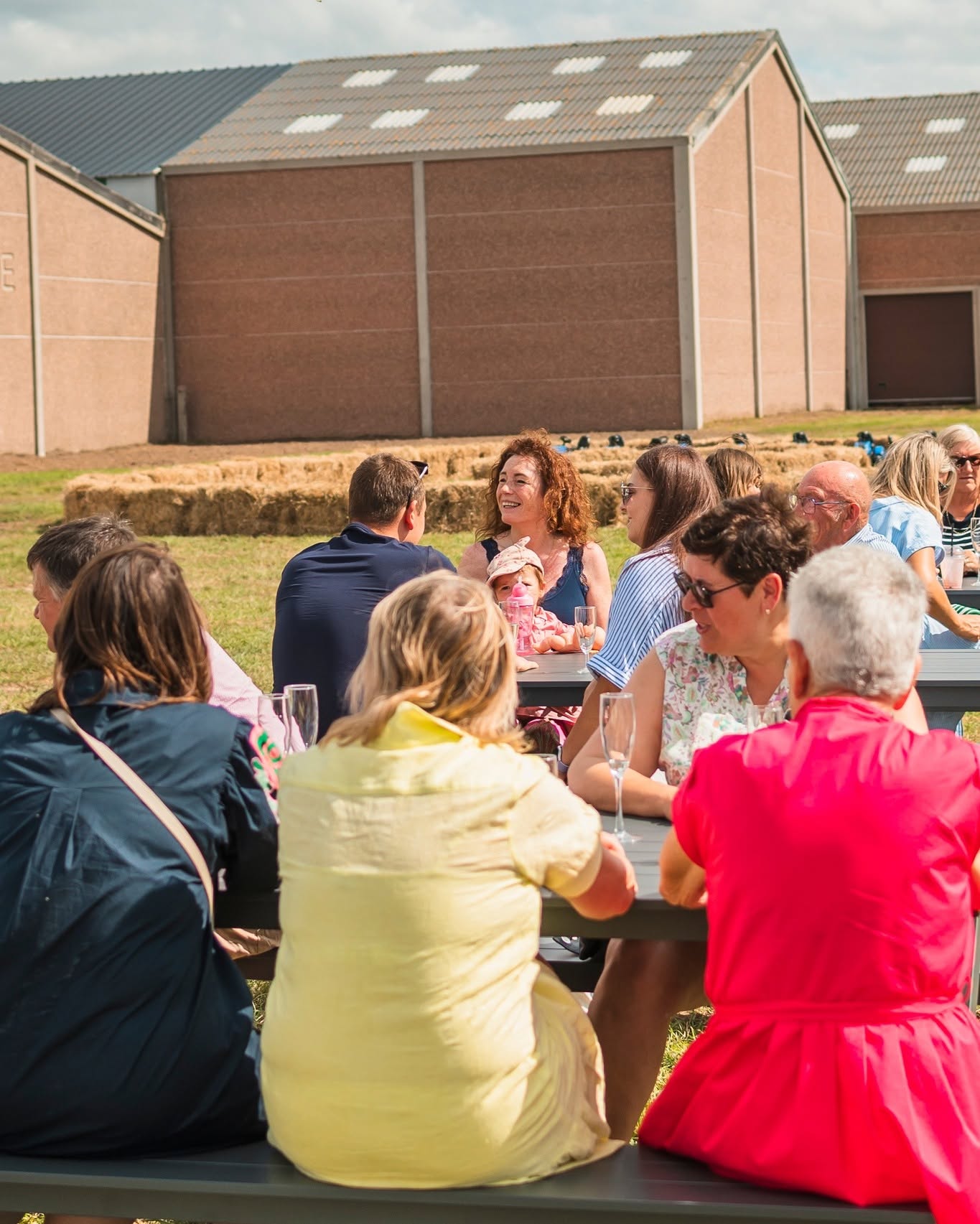 Het zomerterras van Fraisy met picknicktafels vol bezoekers, naast het familiebedrijf in Woumen.
