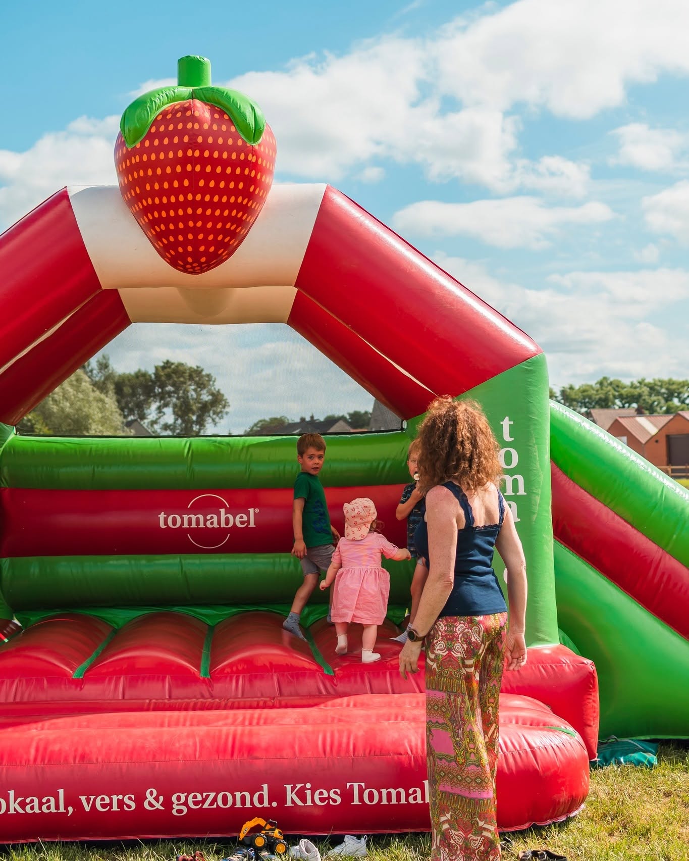 Kinderen spelen op het aardbei-vormige springkasteel op het speelterras van Fraisy.