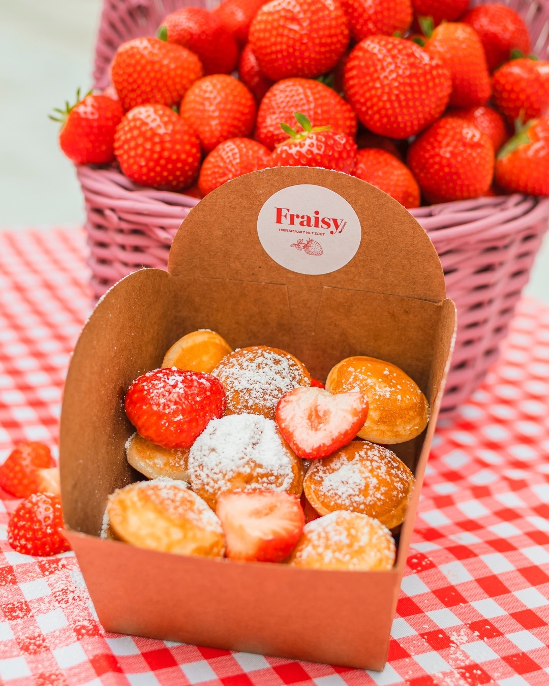 Een boxje poffertjes met verse aardbeien en bloemsuiker van Fraisy.
